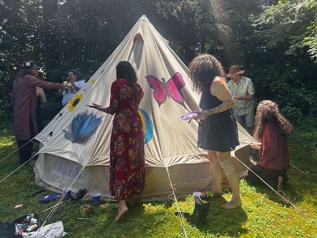 Community painting a tent together
